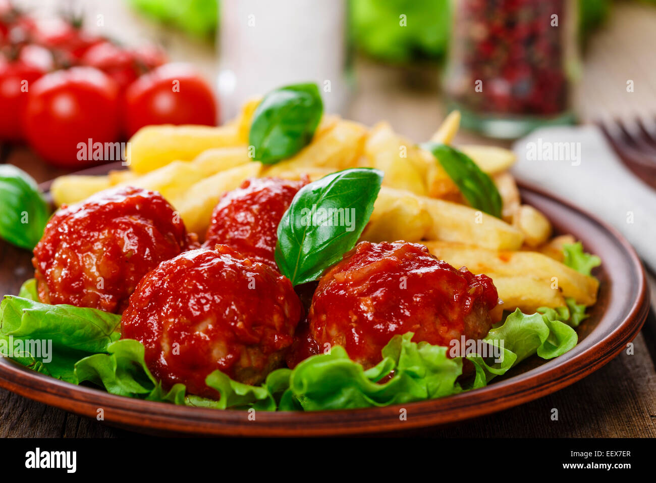 Des boulettes de viande en sauce tomate avec frites Banque D'Images