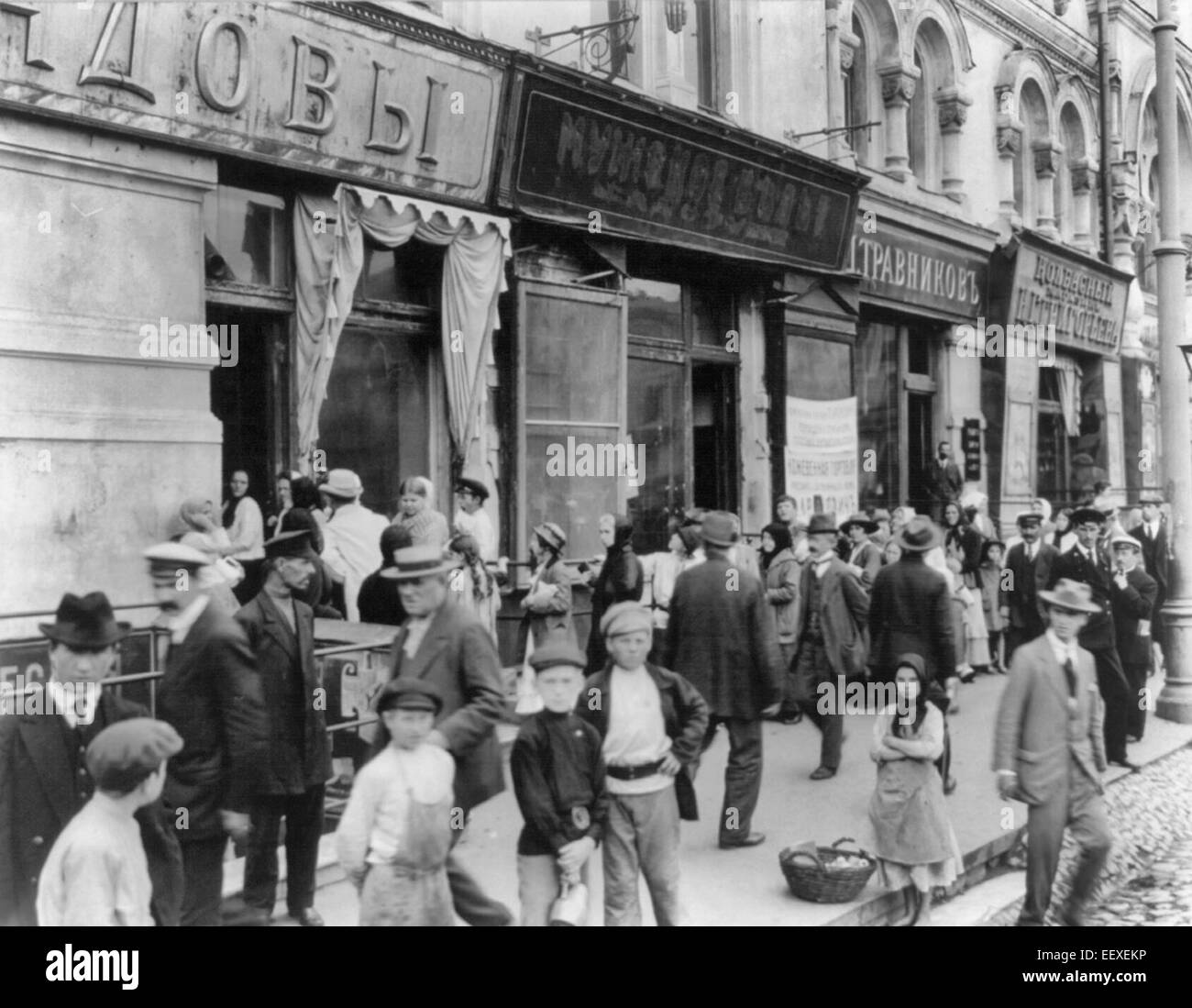 Ligne de lait dans la ville russe ; les femmes et les enfants en longue ligne en attente d'acheter du lait ; marchande de pommes, 1917 Banque D'Images