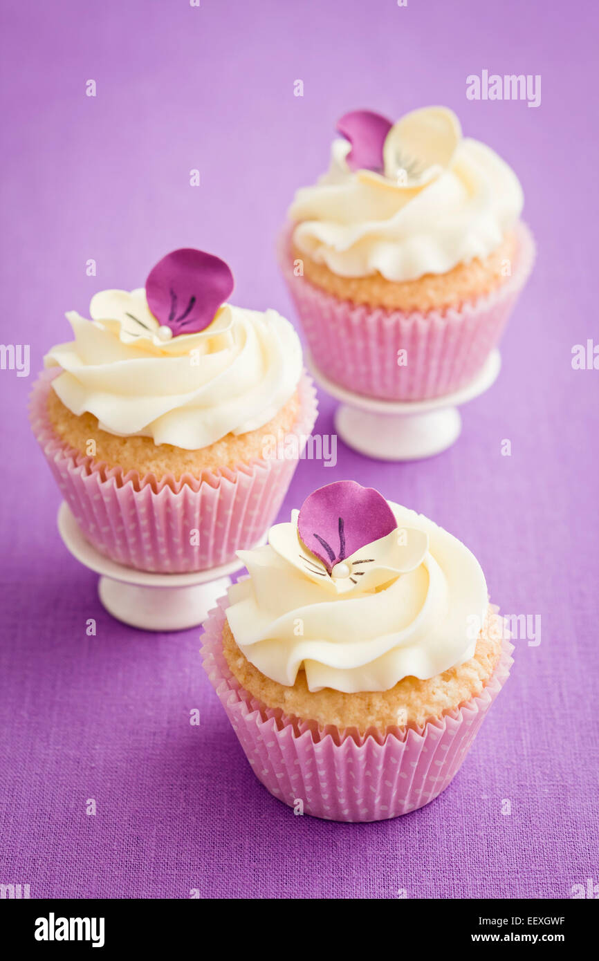 Buttercream Cupcakes avec pansy et fleurs de sucre Banque D'Images