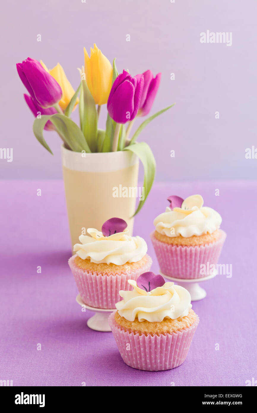 Buttercream Cupcakes avec pansy et fleurs de sucre Banque D'Images