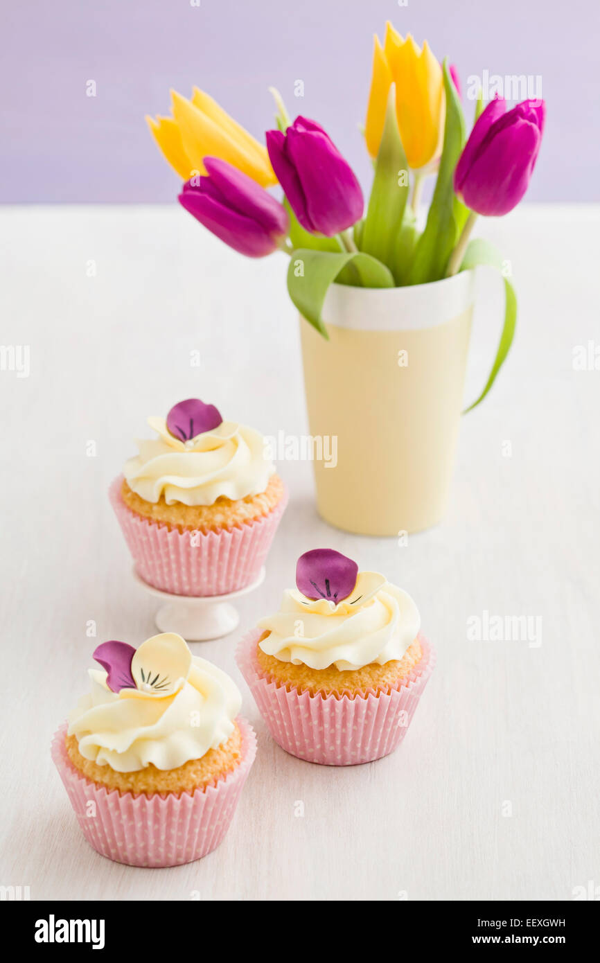 Buttercream Cupcakes avec pansy et fleurs de sucre Banque D'Images