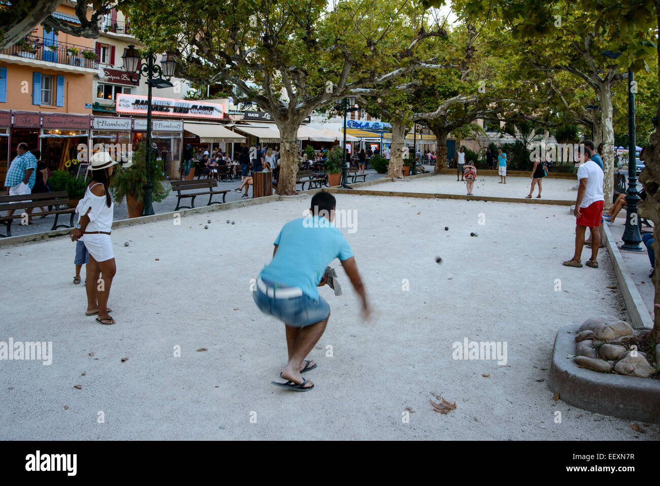 Un groupe de personnes qui jouent le jeu du ballon (la pétanque) en soirée d'été dans Le Lavandou, Var, PACA, France Banque D'Images