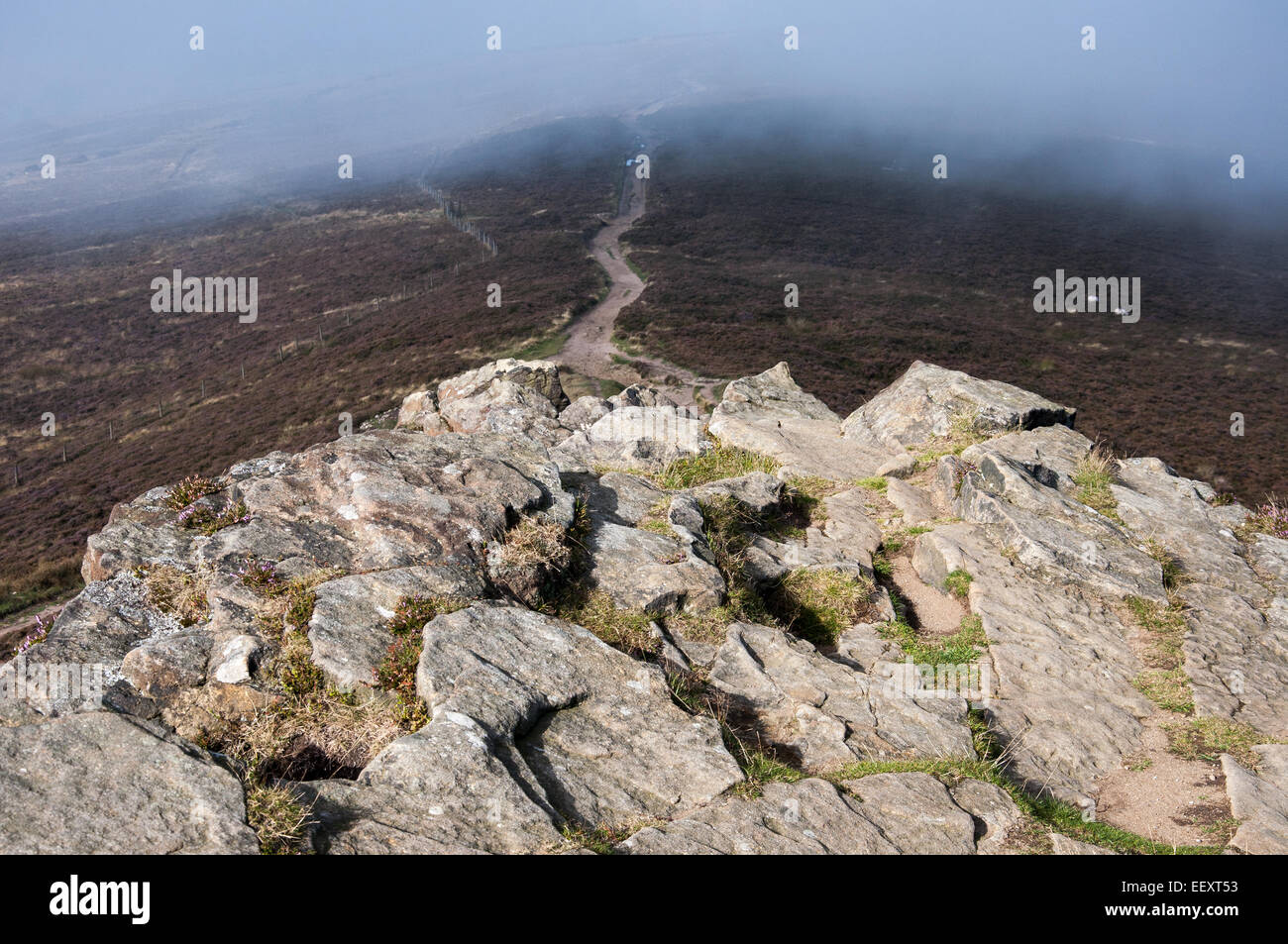 Morning Mist efface du sommet rocheux de Win Hill dans le Peak District, Derbyshire. Banque D'Images