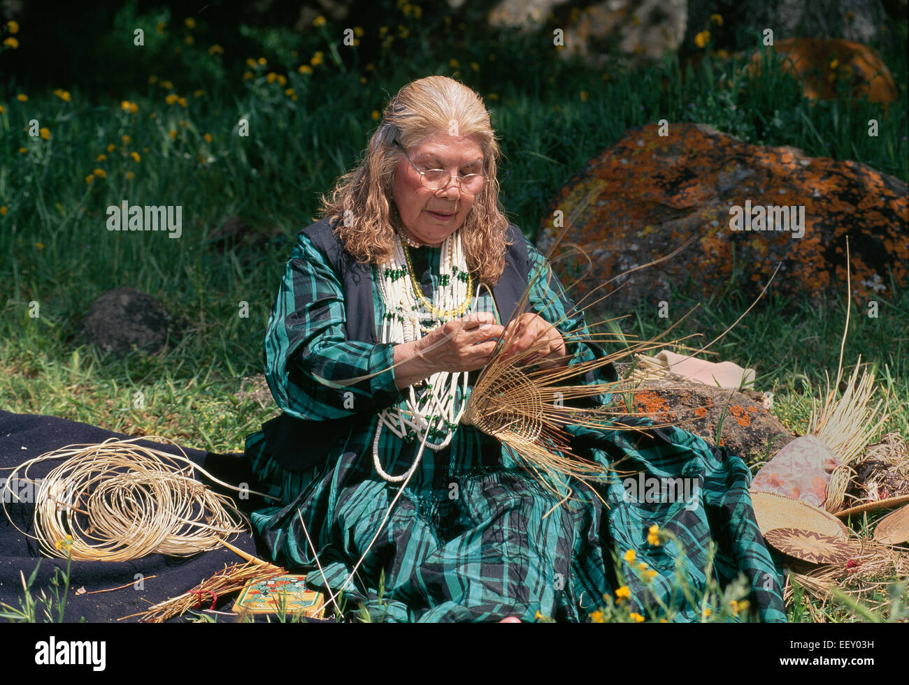 Pomo Kashia Femme tissant traditionnel 'forme conique de la collecte d'acorn panier'. Banque D'Images