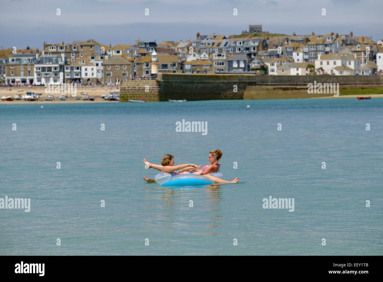 St Ives Cornwall ; détente sur un anneau gonflable dans la mer à St Ives en Cornouailles Banque D'Images