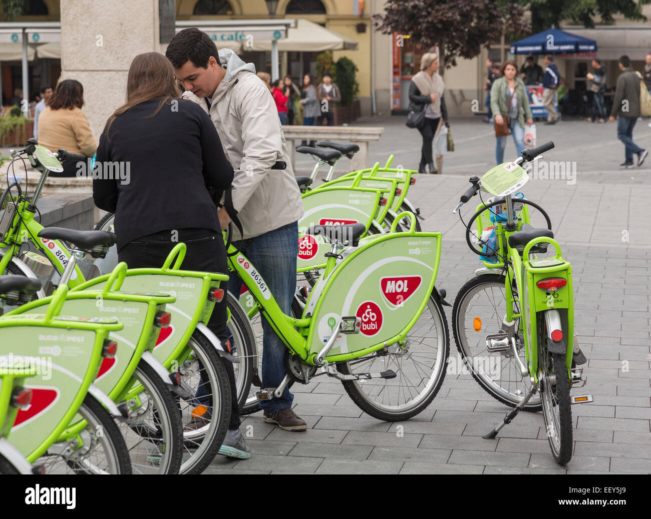 Couple sur le point de louer un des vélos de location appelé MOL ou Bubi NextBike dans les rues de Budapest, Hongrie Banque D'Images