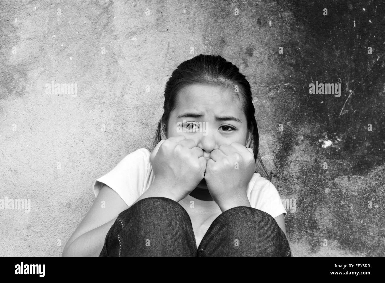 Adolescent asiatique aux traumatismes assis dans un endroit abandonné Banque D'Images