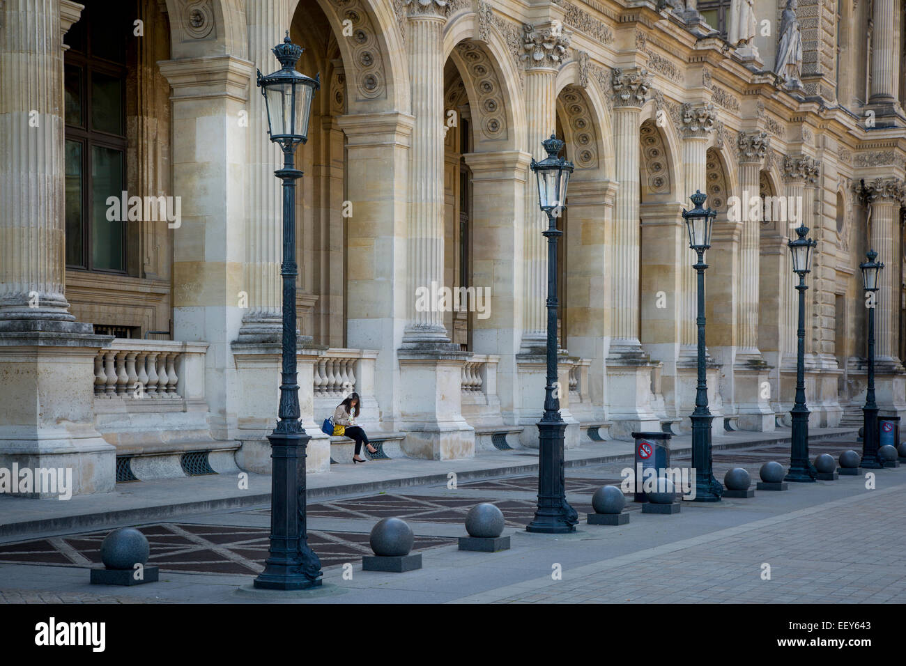 Femme lisant dans la cour du Musée du Louvre, Paris, France Banque D'Images
