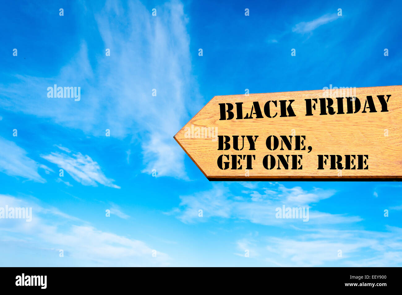 Bois panneau de flèche contre ciel bleu clair avec le Black Friday l'achat un obtiennent un message de vente, conceptual image Banque D'Images
