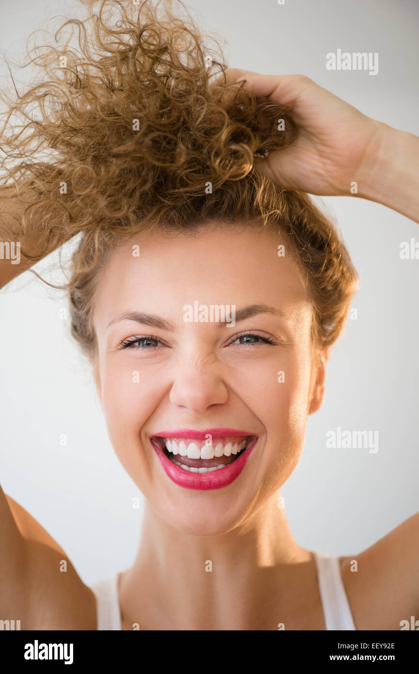 Jeune femme en riant et la tenue de cheveux Banque D'Images