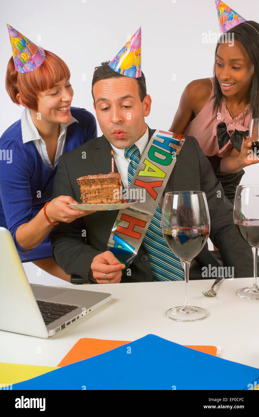 Woman blowing out bougie sur le gâteau d'anniversaire Banque D'Images