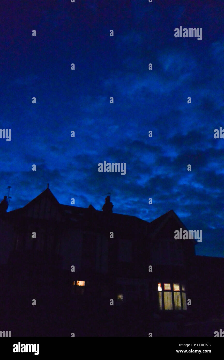 Une chambre de nuit avec les lumières dans la chambre à l'avant avec une couvant ciel au-dessus. Banque D'Images