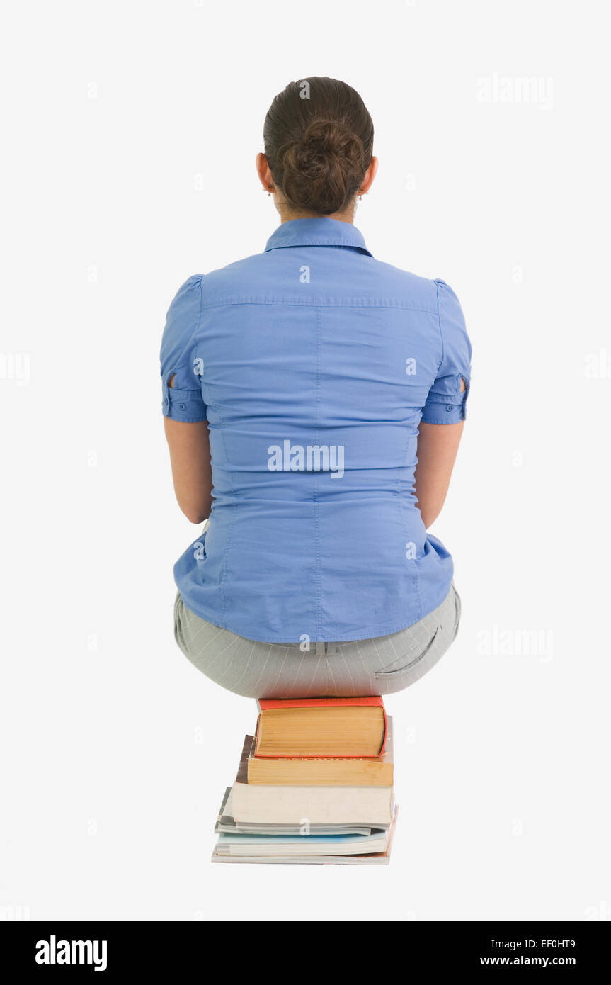 Femme Assise Sur Une Pile De Livres Banque De Photographies Et Dimages