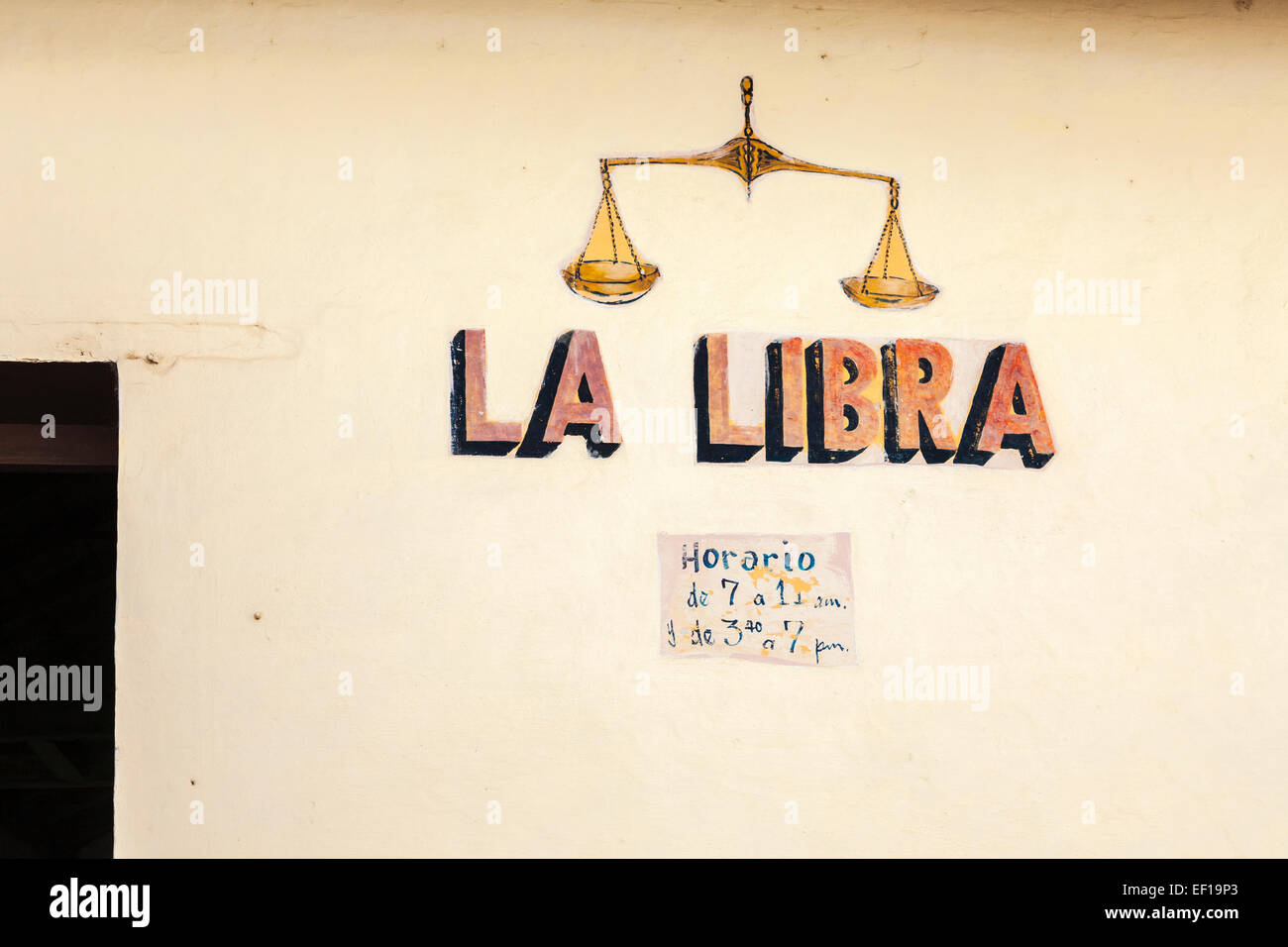 Inscrivez-vous pour un magasin 'La balance' avec des balances et heures d'ouverture peinte sur un mur à Trinidad, Cuba Banque D'Images
