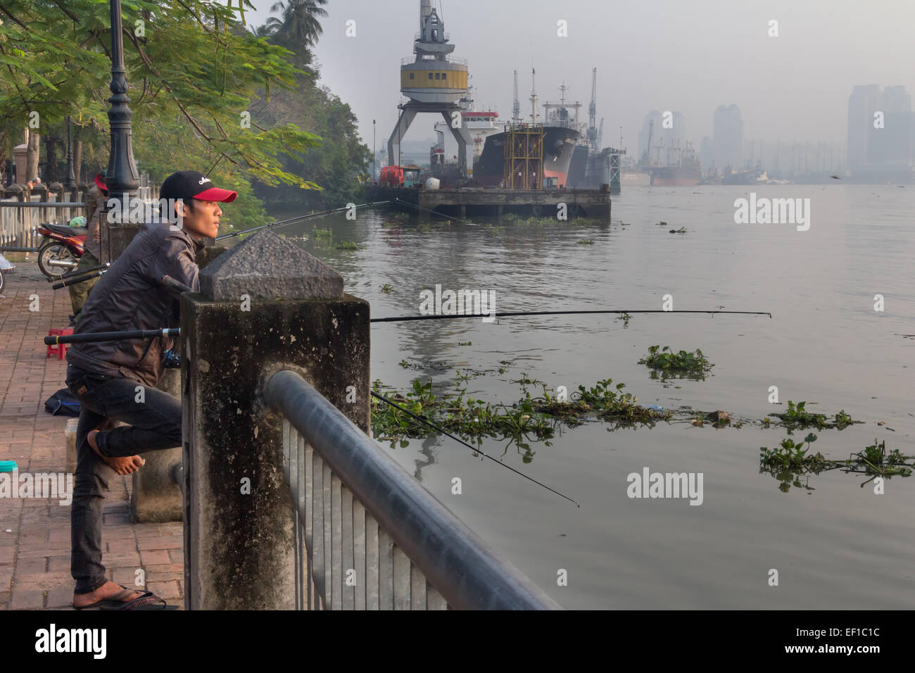 L'homme pêche dans la rivière Saigon, Ho Chi Minh City, Vietnam Banque D'Images