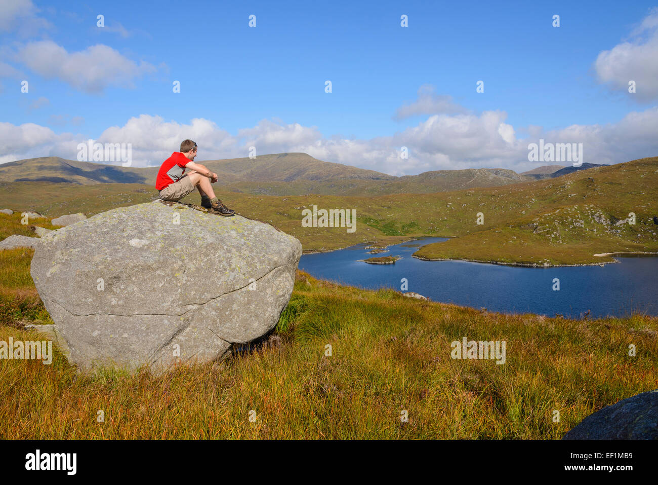 Walker s'assit sur un rocher, admirant vue depuis l'age de l'Jarkness, Galloway Hills, Dumfries et Galloway, Écosse Banque D'Images
