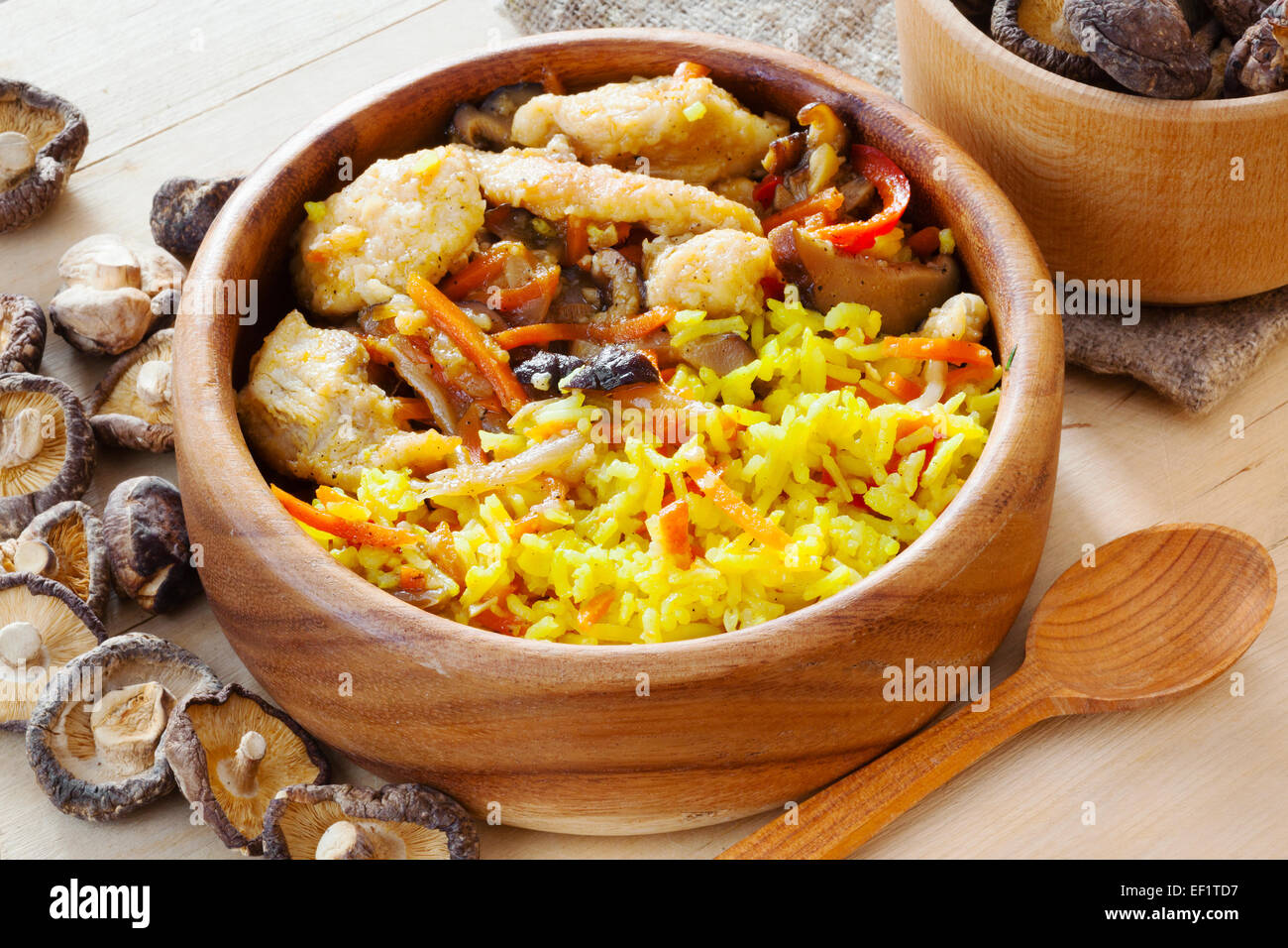 Curry de poulet au riz pilaf et de champignons shiitake bol en bois sur une table de cuisine Banque D'Images
