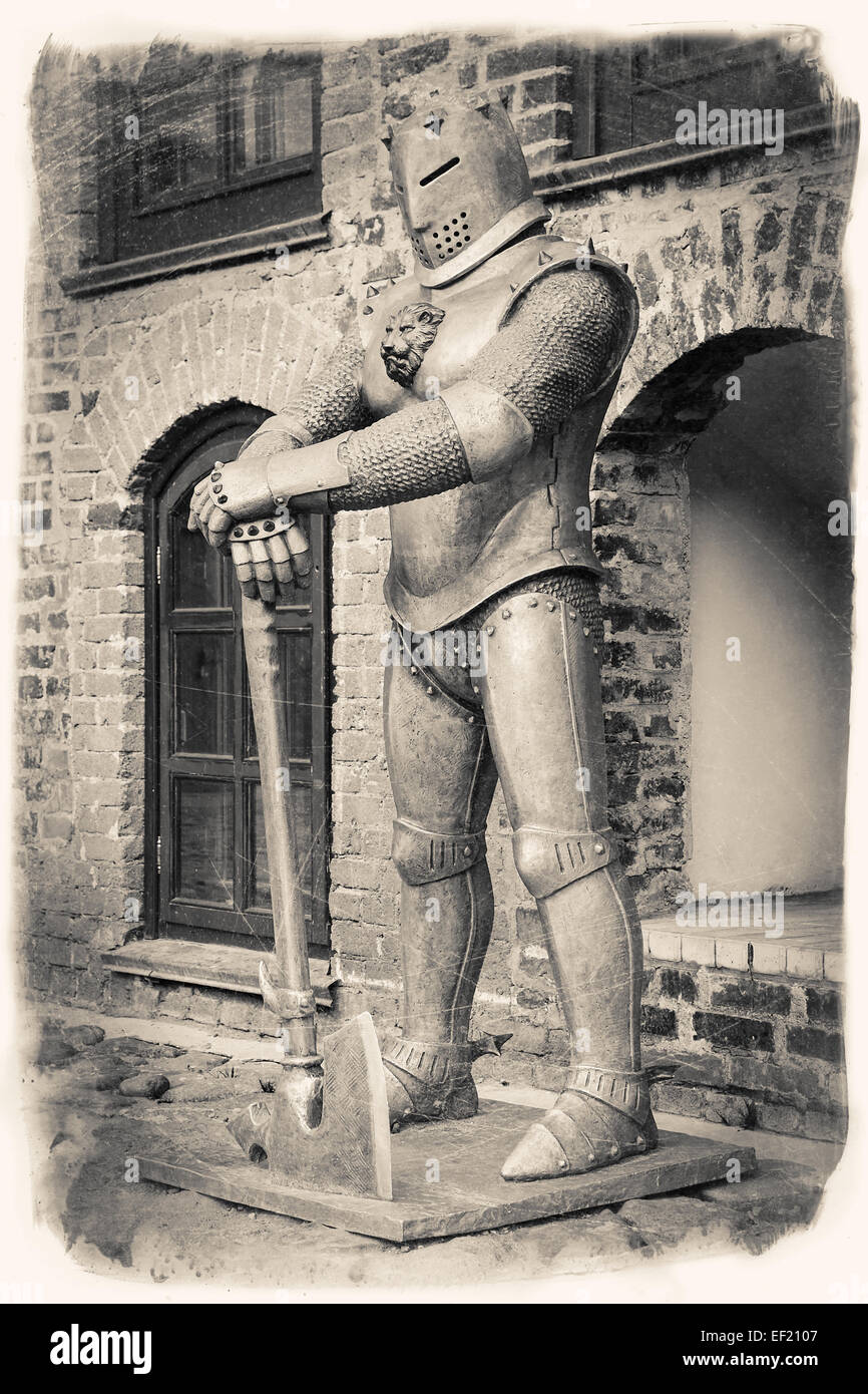 Retro Vintage image stylisée de chevalier médiéval avec ax près de Castle. Banque D'Images