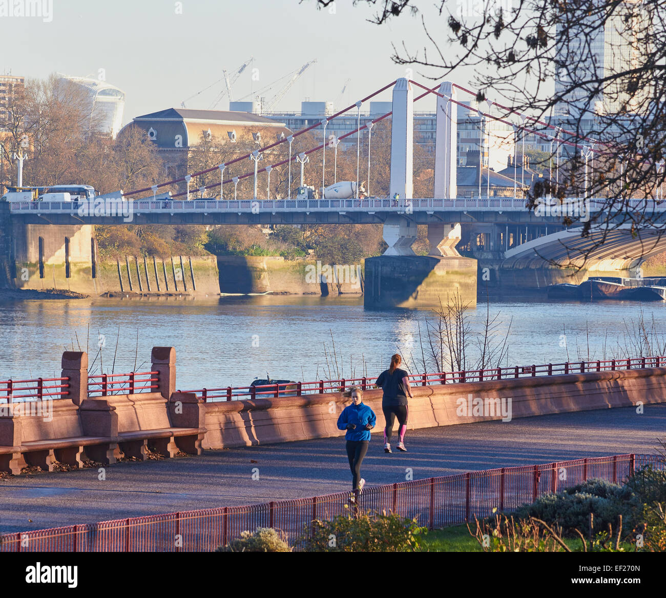 Les coureurs sur un matin d'hiver dans Battersea Park avec tamise et Chelsea Bridge en arrière-plan l'Europe Angleterre Londres Banque D'Images