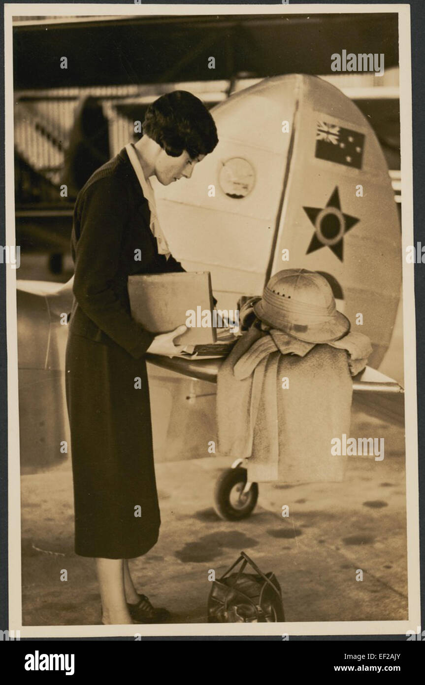 Ce portrait de l’aviateur Jean Batten, pris près de la queue de son avion, capture un moment de sa carrière pionnière dans l’aviation. Batten est connue pour ses vols record dans les années 1930 Banque D'Images