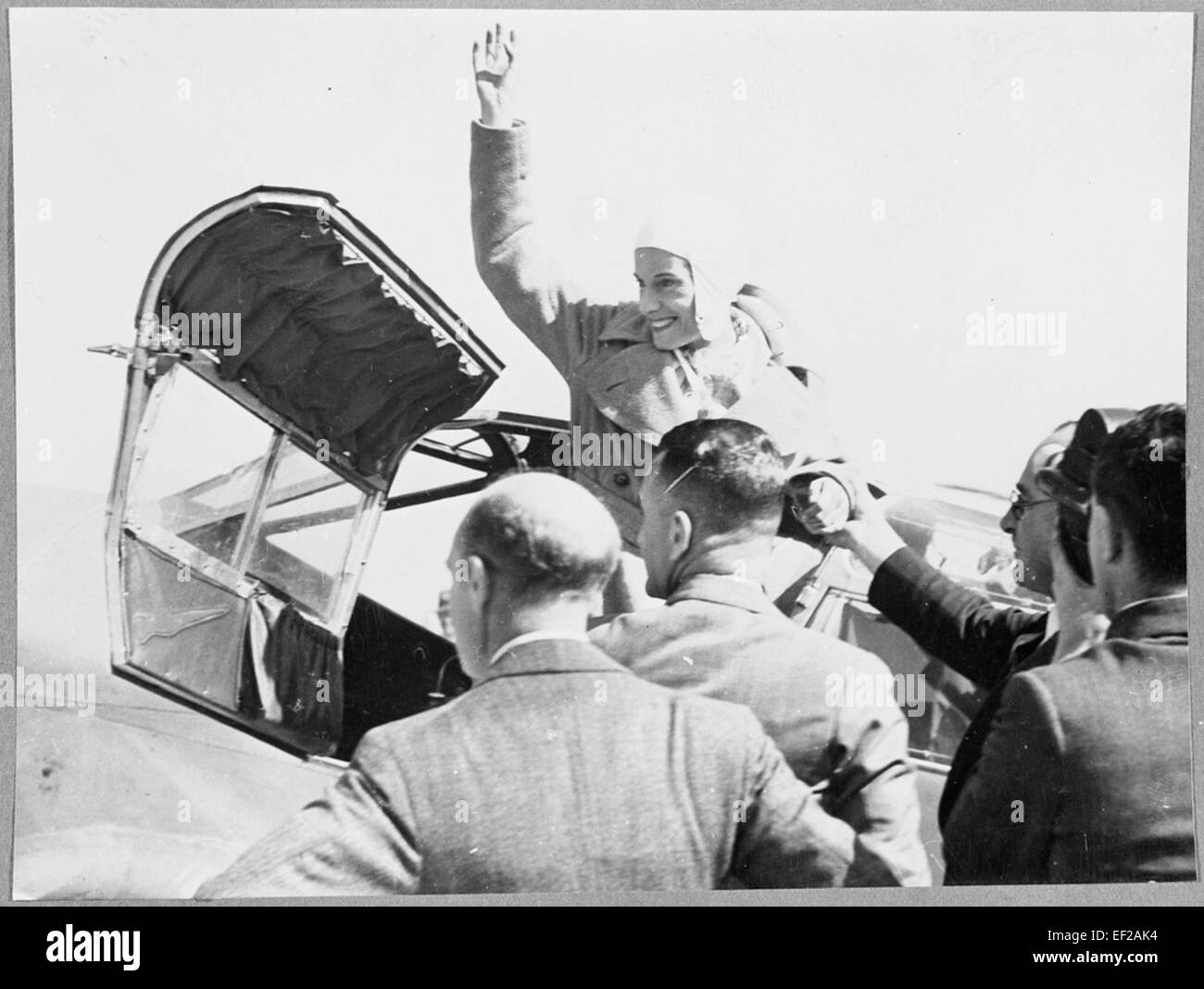 Jean Batten, un aviateur pionnier, est vu agiter alors qu'elle est aidée à sortir du cockpit de son monoplan Percival Gull. Batten a effectué d'importants vols en solo, dont le premier vol en solo de l'Angleterre à la Nouvelle-Zélande en 1936. Banque D'Images