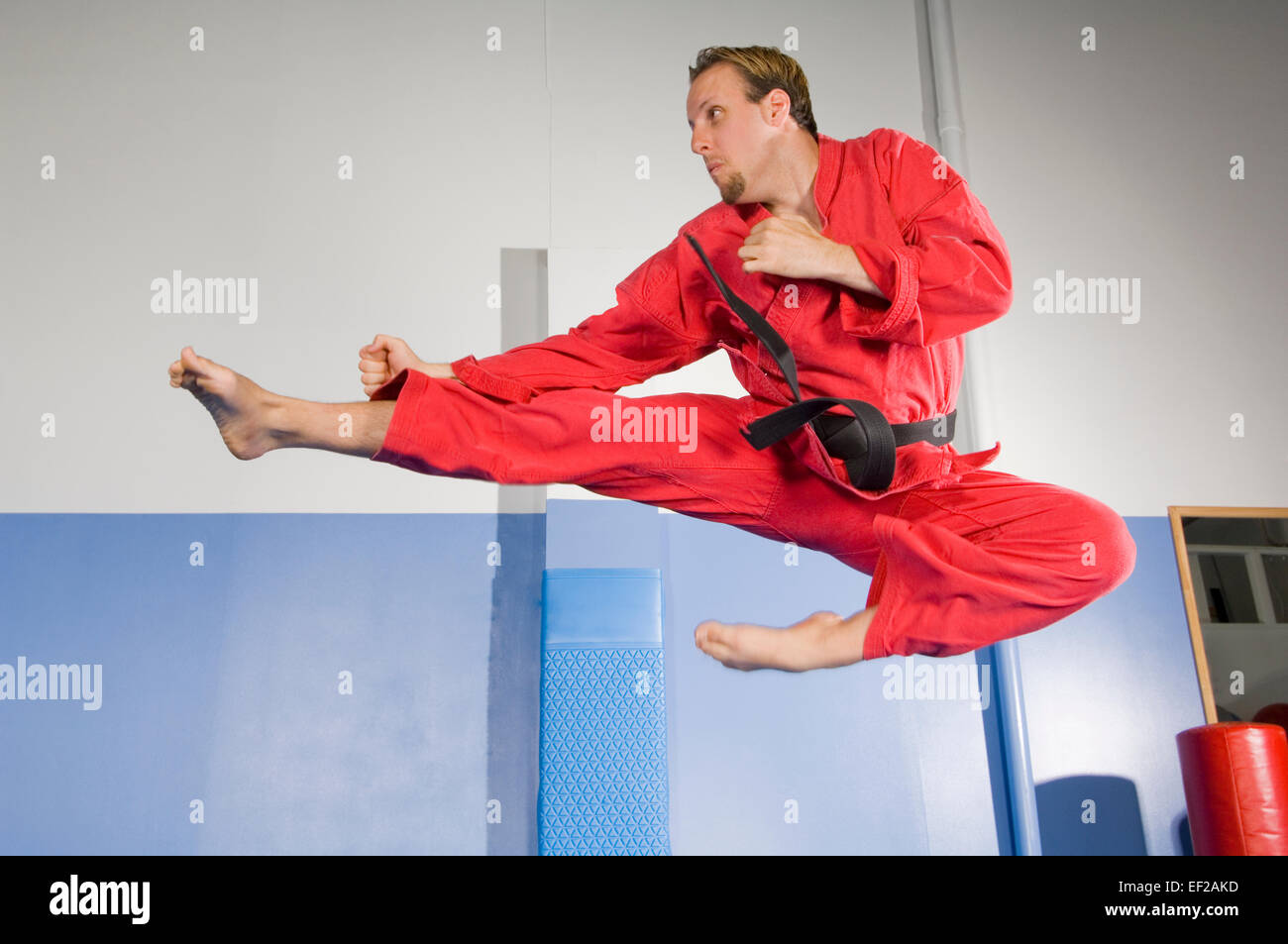 Un homme dans une salle de sport faire un saut de Karaté Banque D'Images