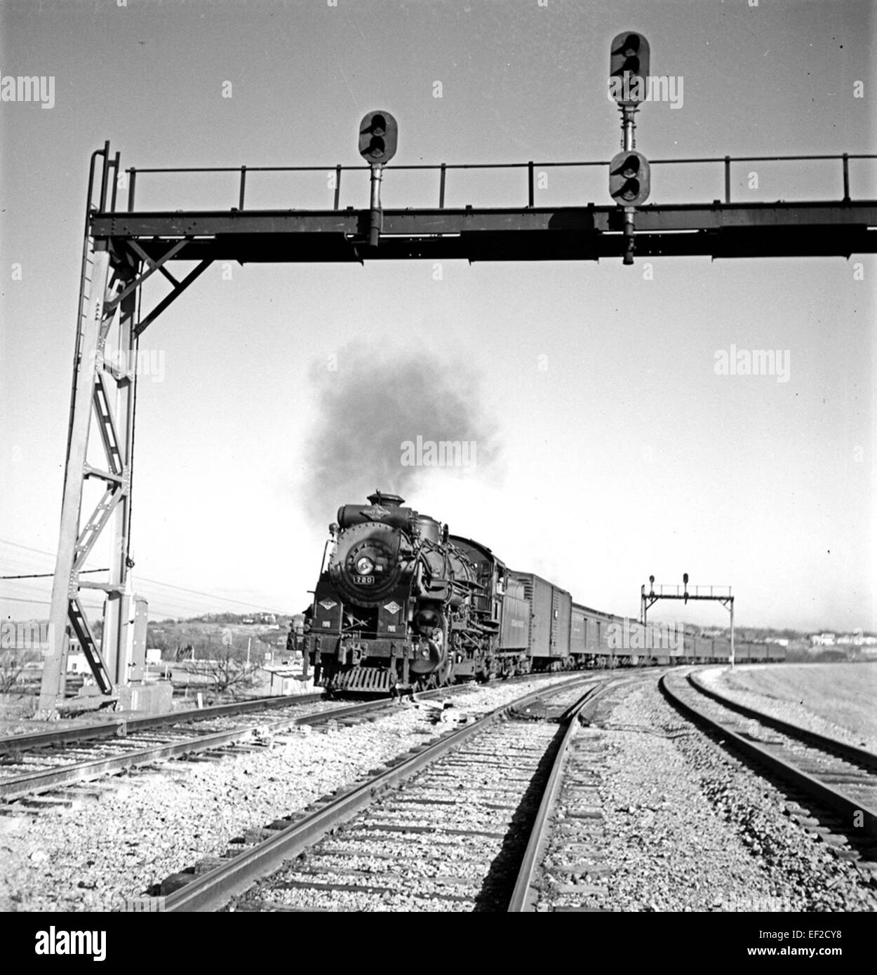 La locomotive 780, qui fait partie de la Texas & Pacific Railway Company, est un élément clé de l'histoire du chemin de fer américain. Cette locomotive, présentée avec le pont de signalisation ferroviaire, représente les progrès technologiques dans le transport ferroviaire. Il a joué un rôle crucial dans le système de fret, fonctionnant avec divers appels d'offres et wagons de marchandises pour transporter des marchandises à travers les États-Unis Banque D'Images