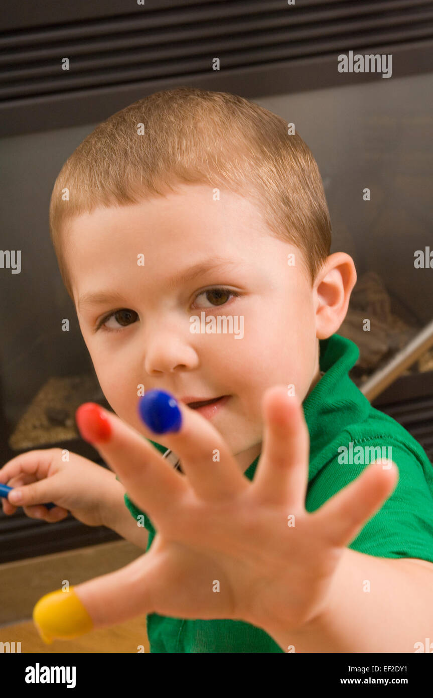 Jeune garçon avec de la peinture sur ses doigts Banque D'Images