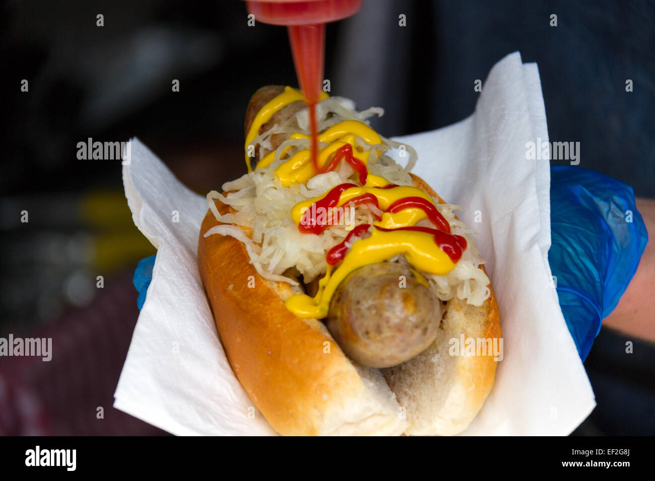 Hot-dog saucisse en préparation avec des oignons à Wapping, marché Quai Bruxelles, Shadwell Basin, London, E1W Banque D'Images