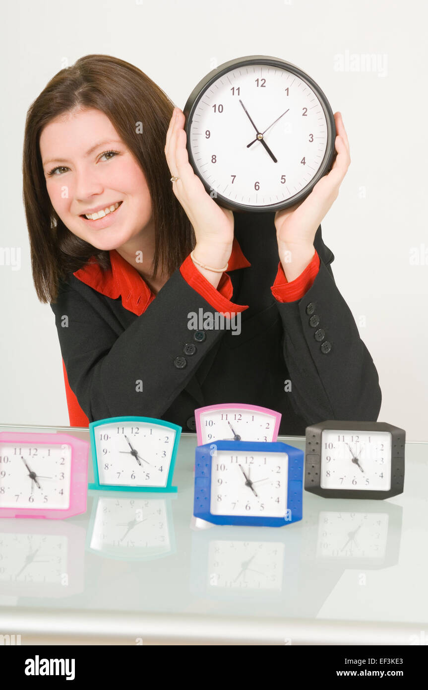 Businesswoman holding a clock Banque D'Images