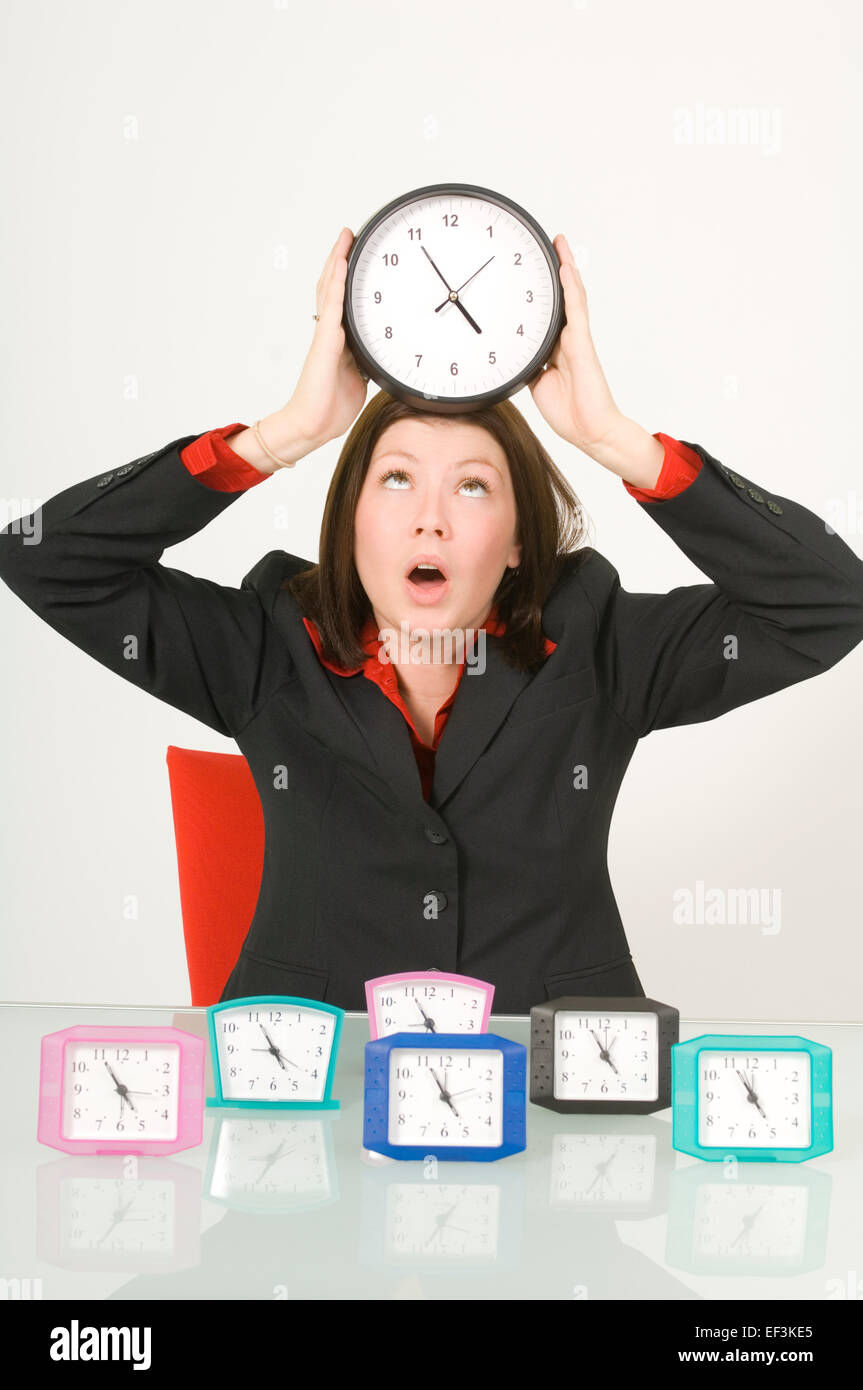 Businesswoman holding une horloge sur sa tête Banque D'Images
