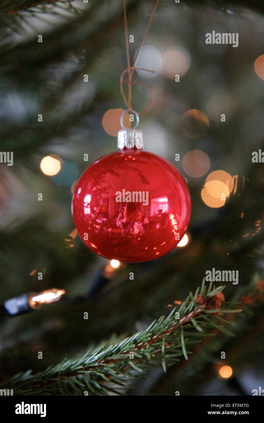 Bauble hanging verre de noël avec lumières derrière twinkly Banque D'Images