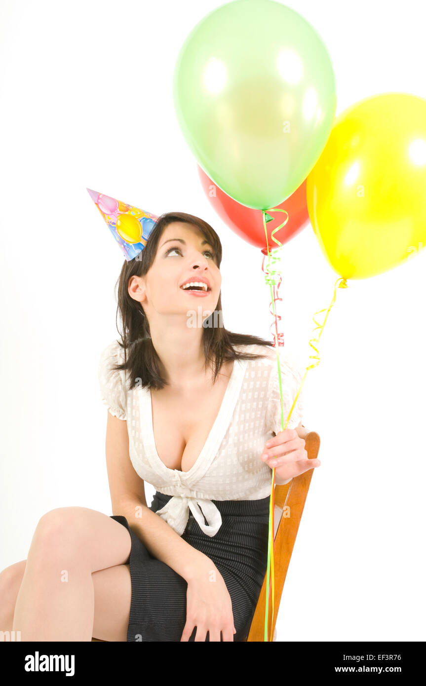 Woman wearing party hat and holding balloons Banque D'Images