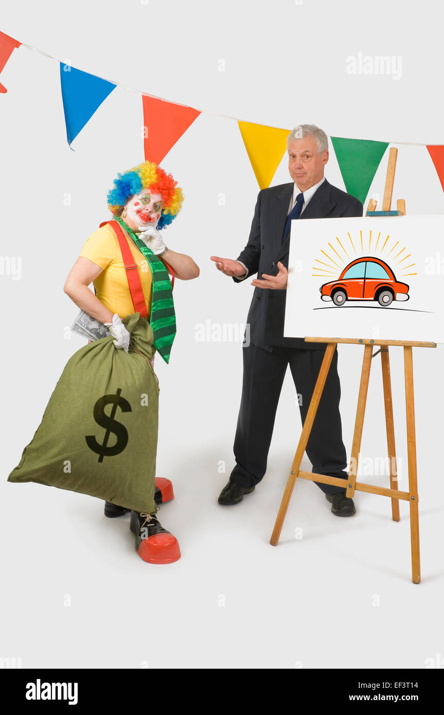 Clown tenant un sac d'argent à côté d'un vendeur de voiture Banque D'Images