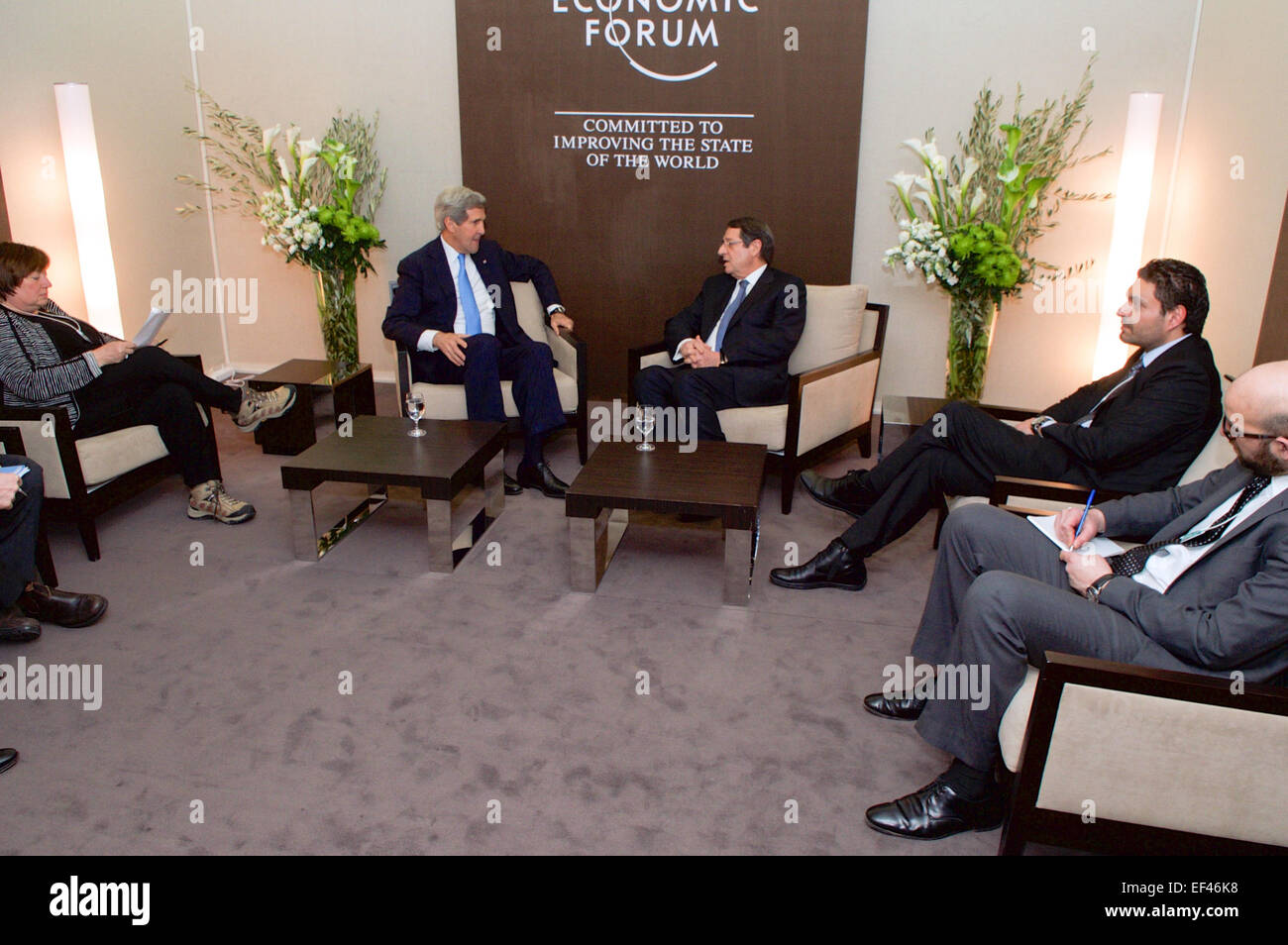 Le secrétaire d'Etat John Kerry, rejoint par le sous secrétaire d'État pour la croissance économique, de l'énergie, et de l'environnement Catherine Novelli, à gauche, est assis avec le président chypriote Nicos Anastasiades et ses conseillers le 23 janvier 2015, avant que les deux s'assirent pour une rencontre bilatérale en marge du Forum économique mondial à Davos, en Suisse. Banque D'Images