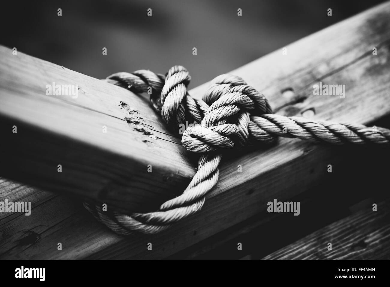 Corde avec noeud sur poutre en bois. Style de film noir et blanc couleurs. Banque D'Images