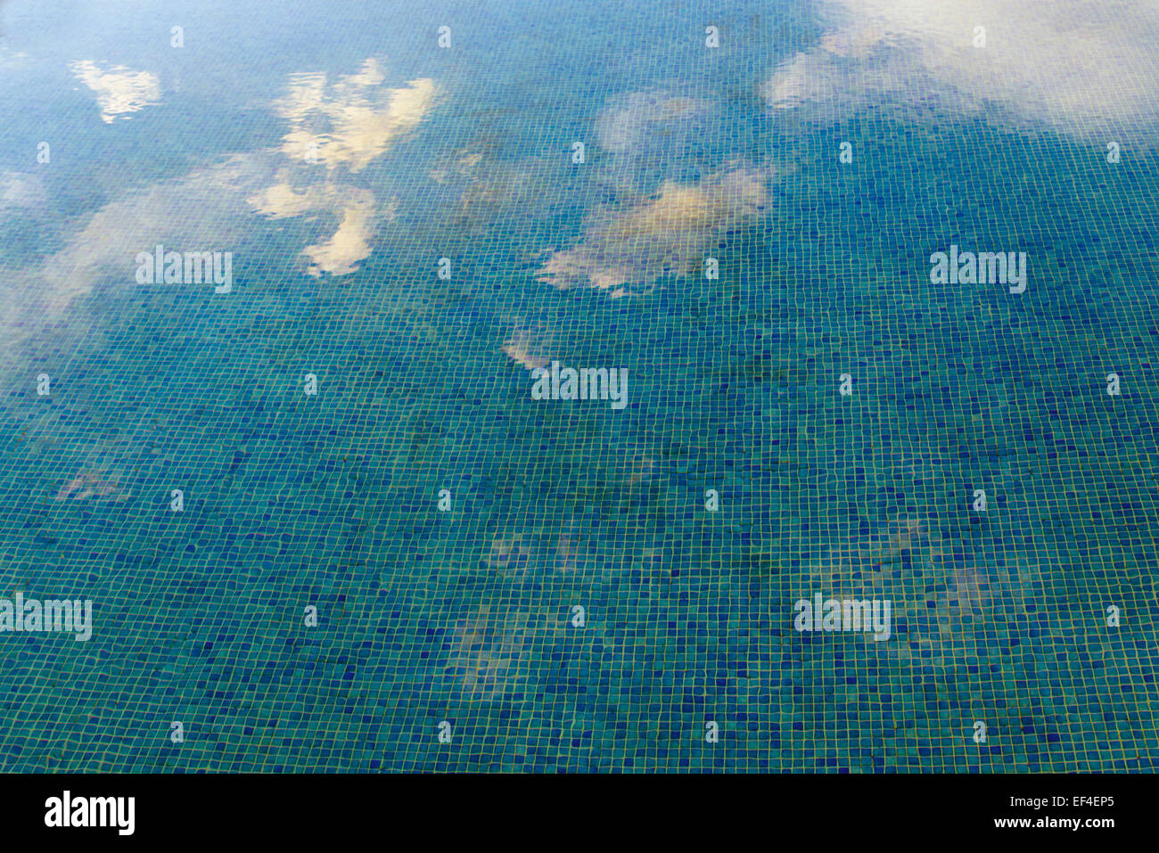 Les nuages reflètent dans l'eau d'une piscine Banque D'Images