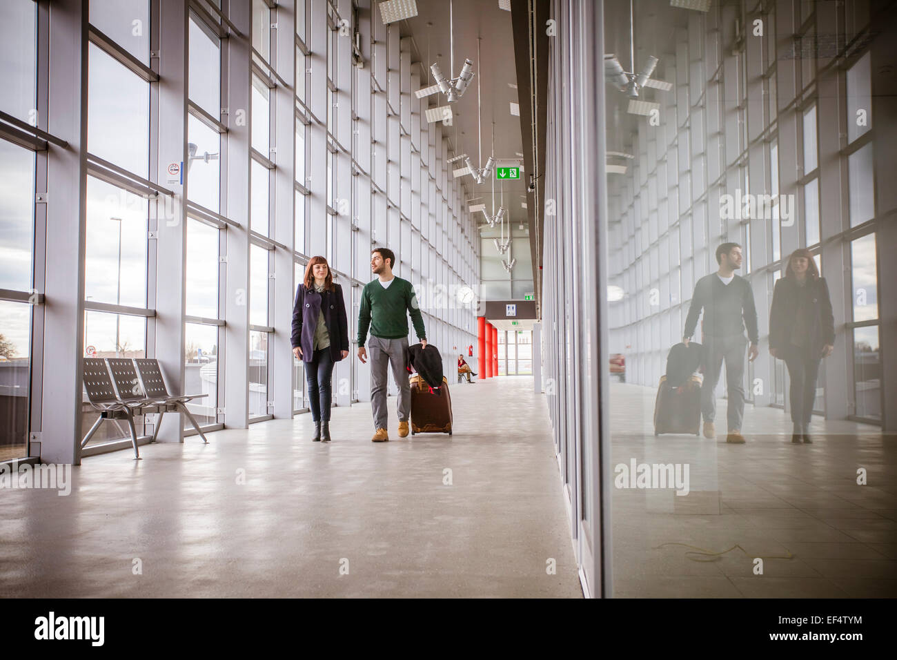Jeune couple avec lugggage en bâtiment de l'aéroport Banque D'Images