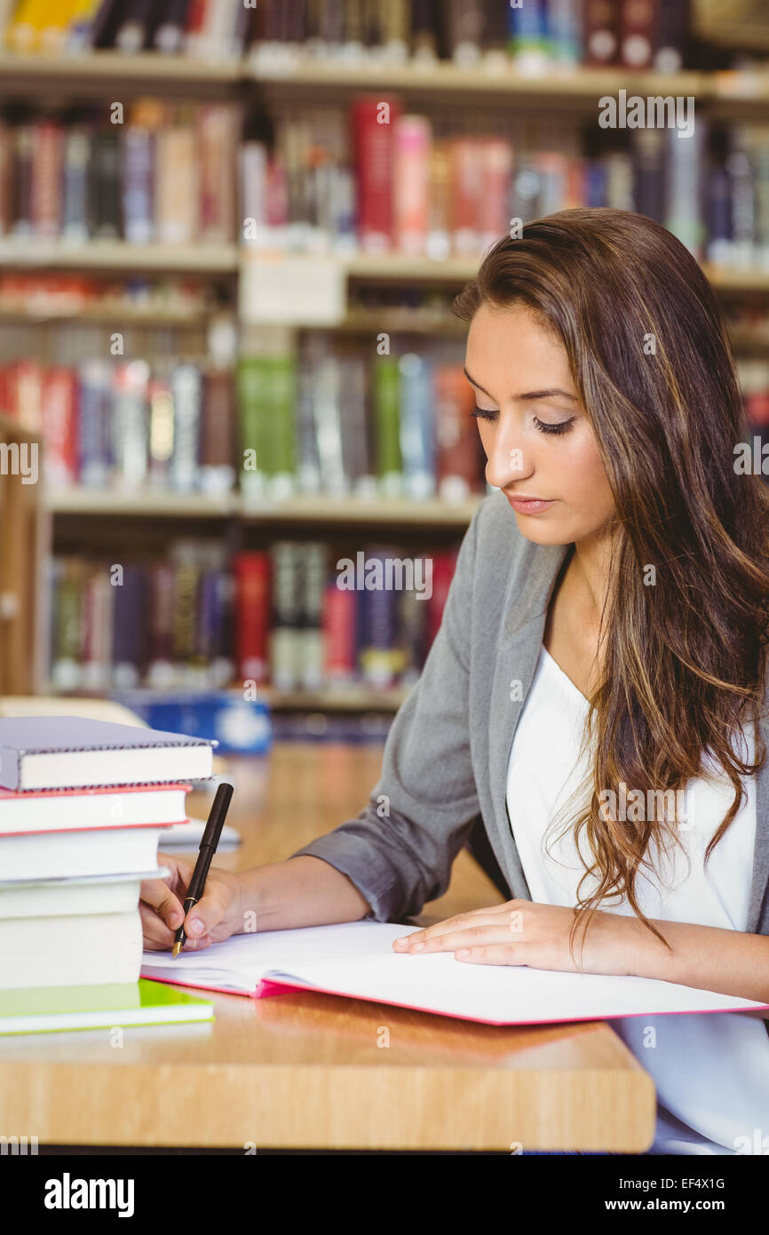 La concentration brunette étudiant travaillant son affectation Banque D'Images