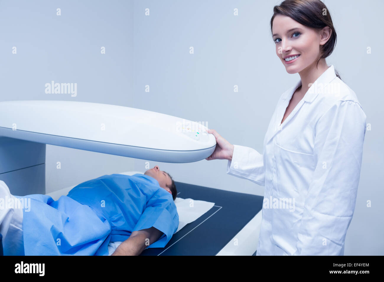 Smiling doctor avec un patient sous l'appareil à rayons x Banque D'Images