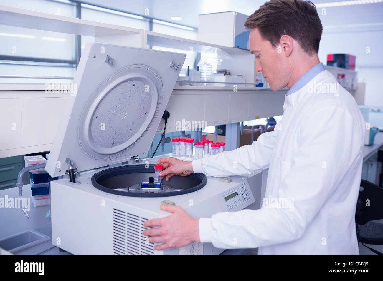 Chemist in lab coat à l'aide d'une centrifugeuse Banque D'Images