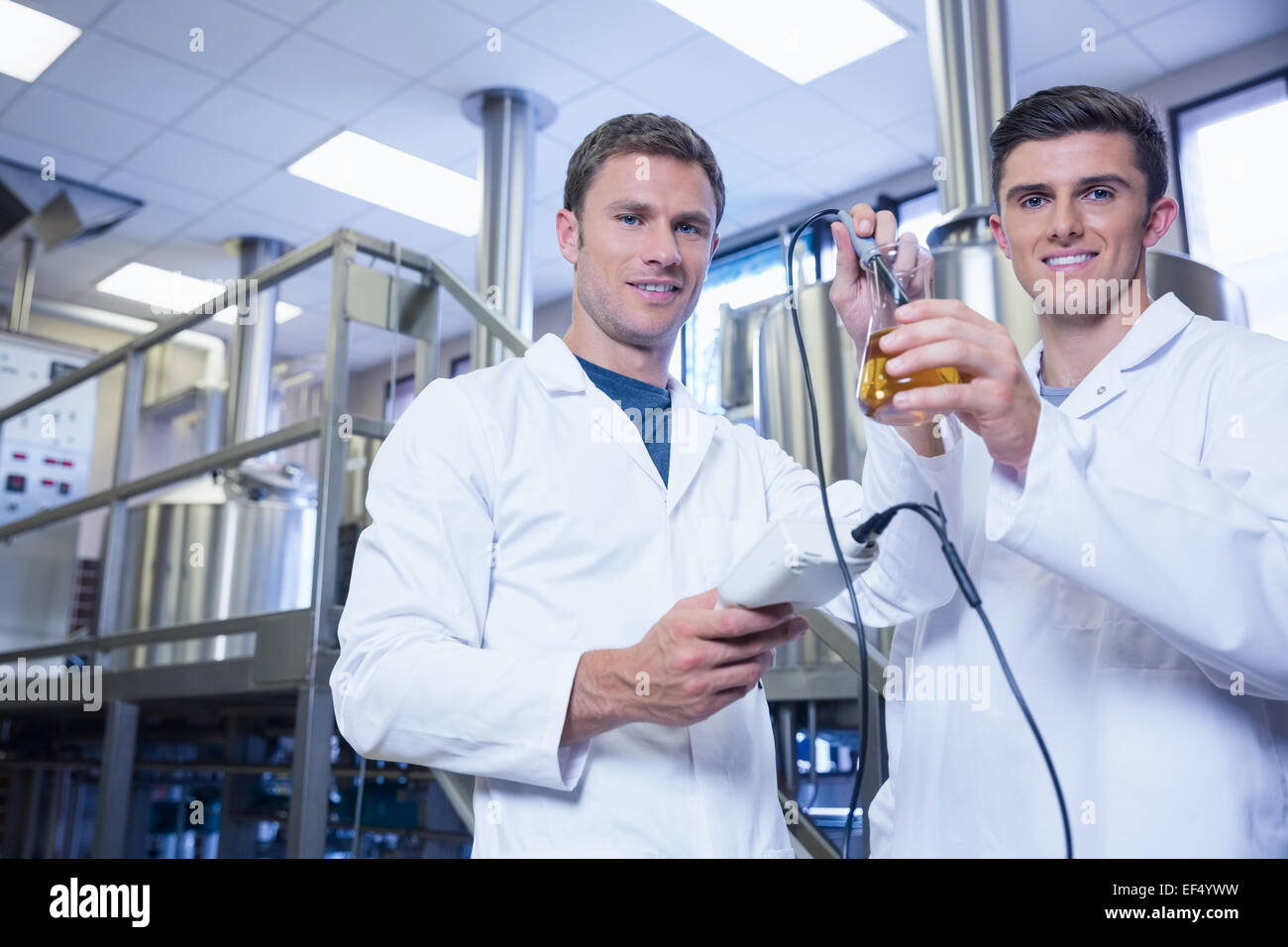 Les hommes tests produits et smiling at the camera Banque D'Images