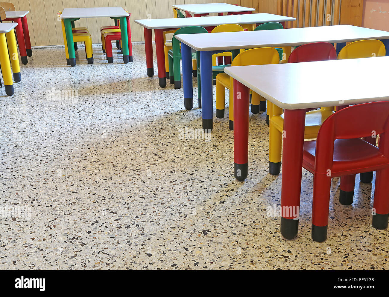 Chaises de couleur et de petites tables dans la salle à manger de la