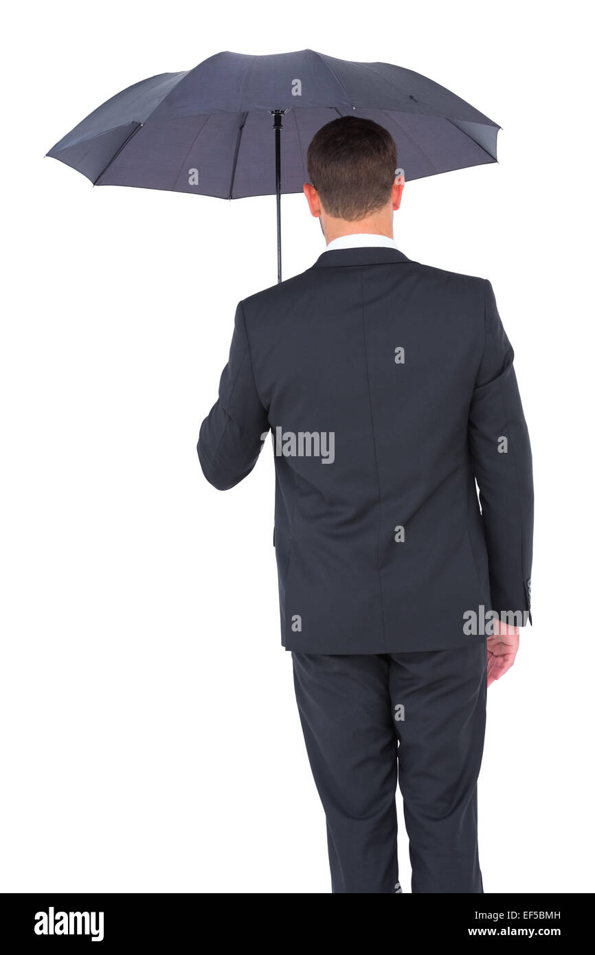 Businessman s'abritant sous parapluie noir Banque D'Images