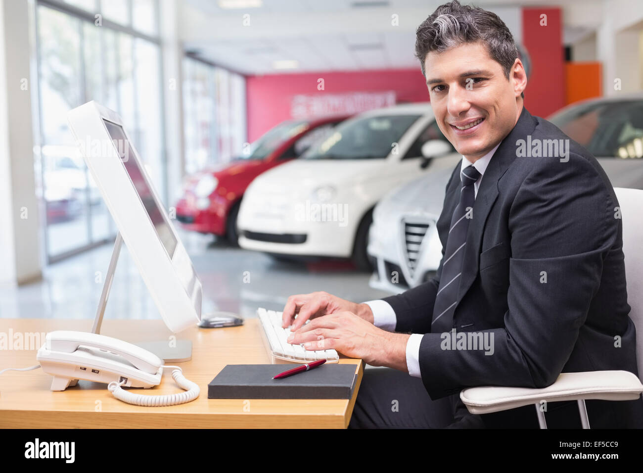 Smiling businessman typing on laptop Banque D'Images