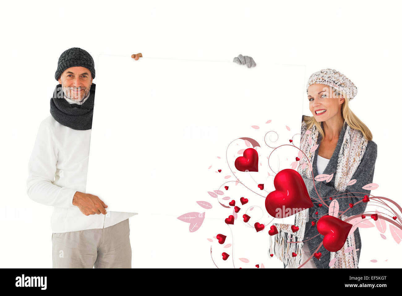 Portrait of couple in winter fashion holding poster Banque D'Images