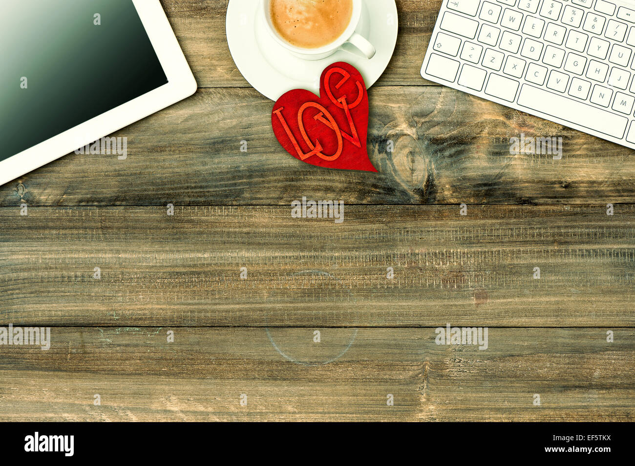 Red love heart, tablet pc, le clavier et le café sur la table en bois. Valentines Day de travail. Retro style tonique photo Banque D'Images