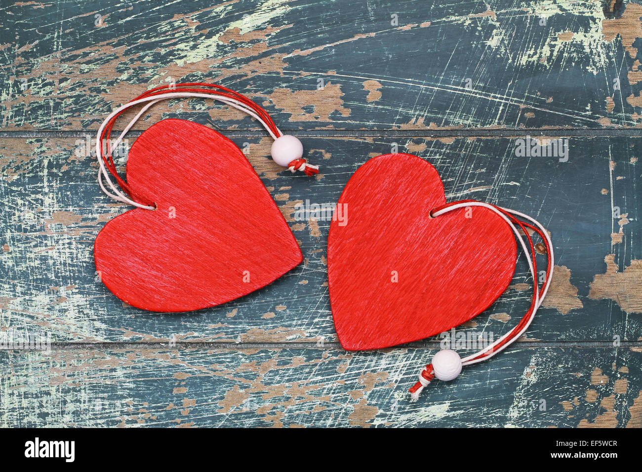 Deux coeurs en bois rouge sur la surface en bois rustique Banque D'Images