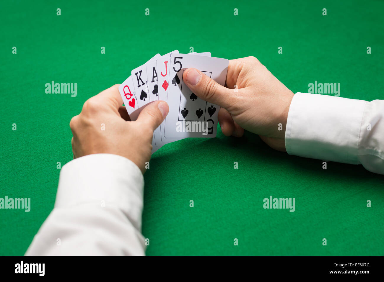 Poker player holding jeux de cartes chez casino table Banque D'Images