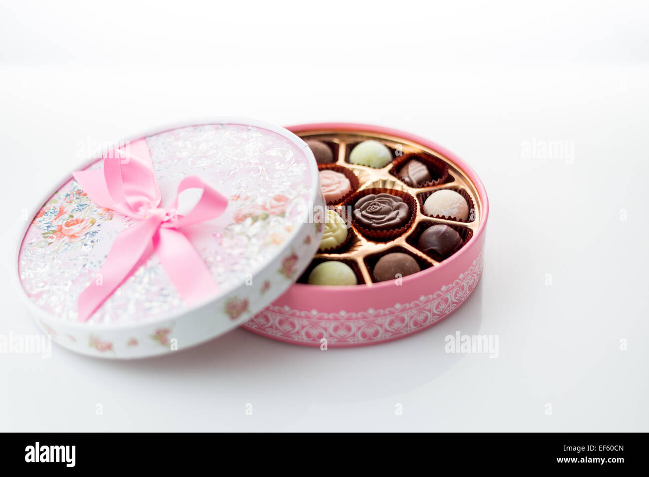Boîte de chocolats rose avec ruban sur fond blanc Banque D'Images